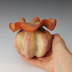 Sculptural vessel with bold ribbing and a delicate, ruffled aperture.  Wet-felted merino wool and silk.