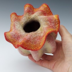 Sculptural vessel with bold ribbing and a delicate, ruffled aperture.  Wet-felted merino wool and silk.