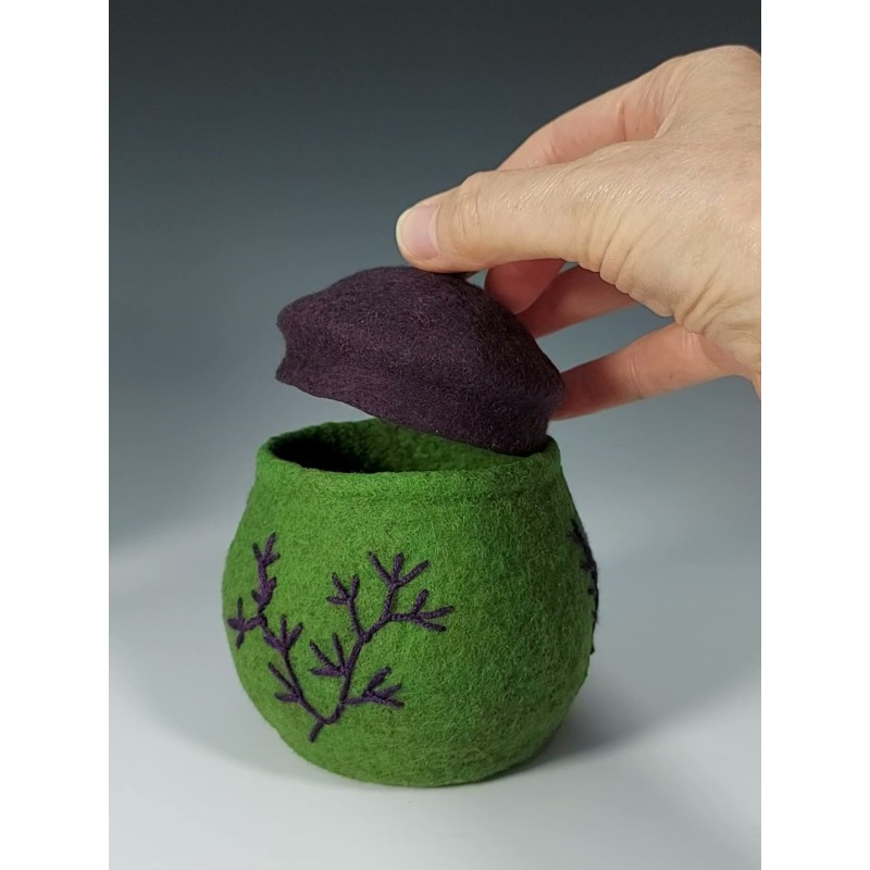 Small green felted pot with embroidery and a purple lid.
