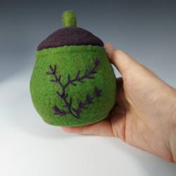 Small green felted pot with embroidery and a purple lid.