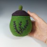 Small green felted pot with embroidery and a purple lid.