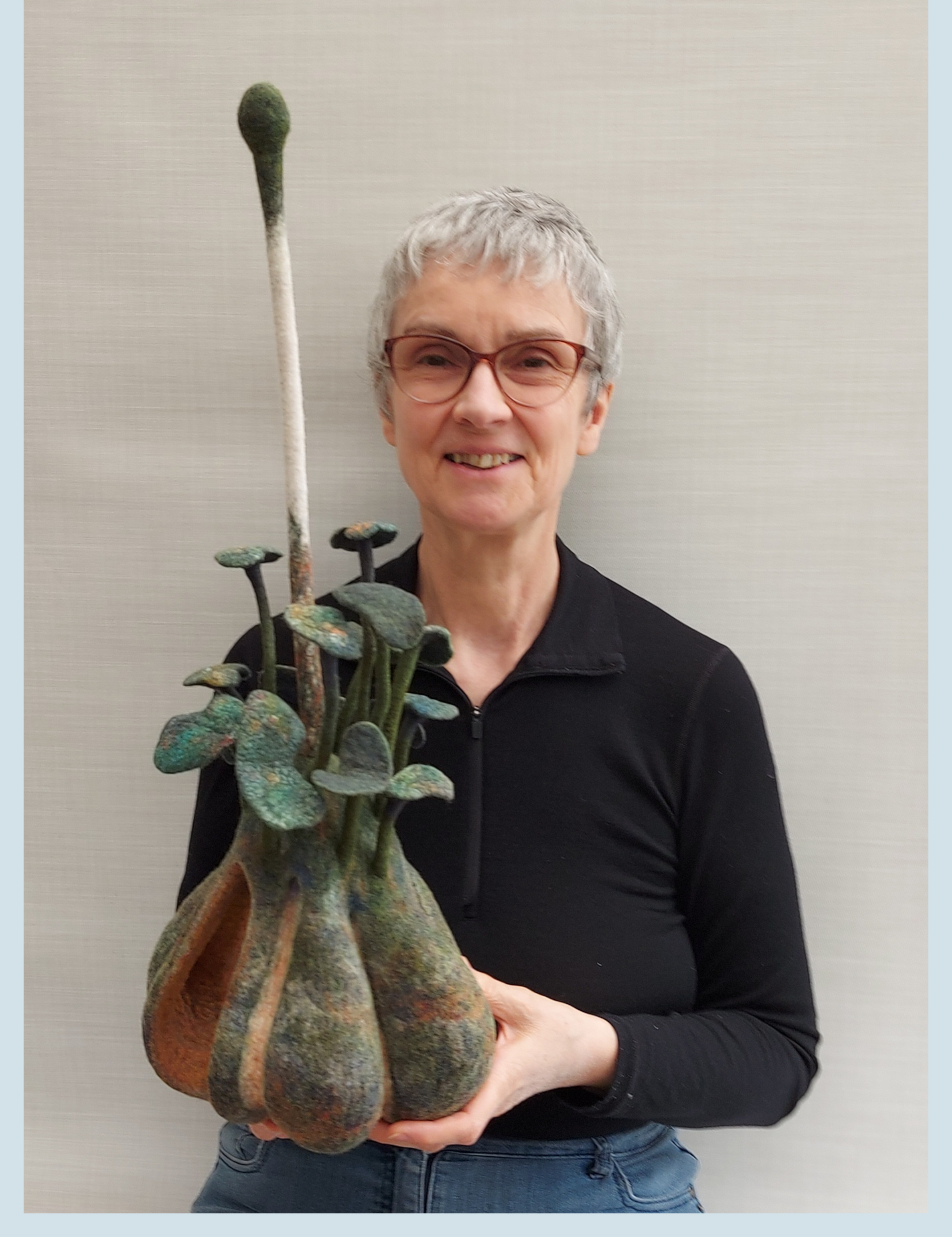 Kathy holding her sculpture "Decay and Renewal"